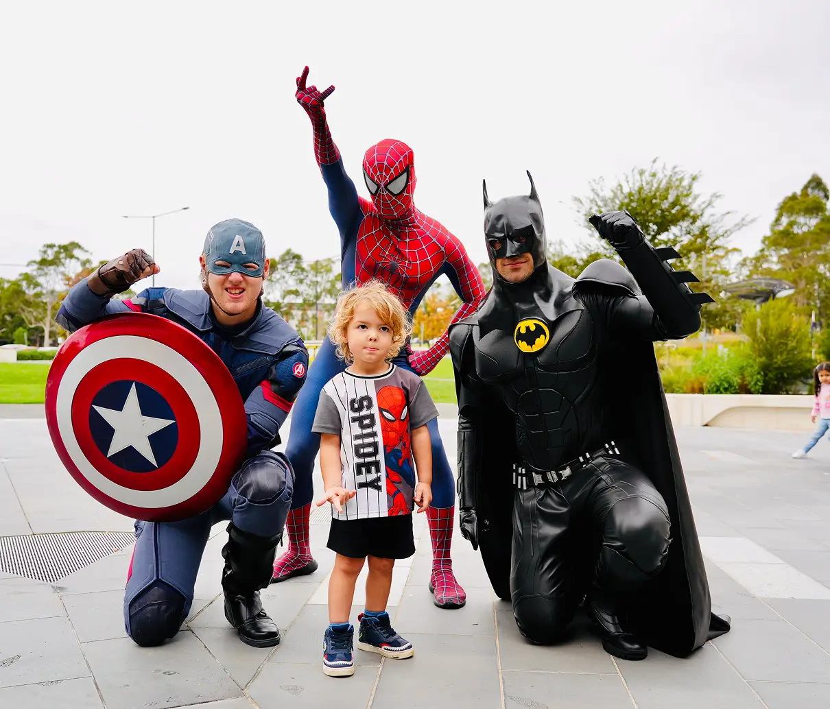 Superheroes posing with a child